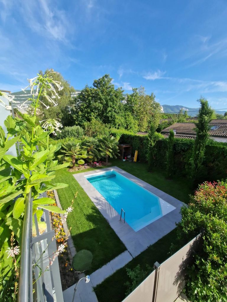 Piscine extérieure dans jardin paysager avec vue sur collines